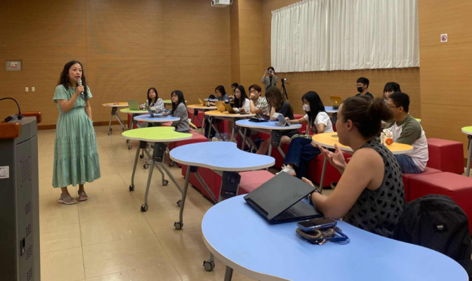 Professor Lu Tang (standing on the left) engaged in an in-depth discussion on AI literacy with students and faculty. (Photo by GCIT)