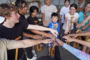 Competitors joined hands in an encouraging group huddle to build team spirit. (Photo by Chinese Language Center)(Open new window/jpg file)Image