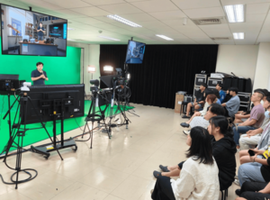 Peter Su, FOREVERTEK Post-Production Department Manager, demonstrates the Edison system interface and virtual-real compositing techniques inside a professional virtual studio, allowing students to experience future video-production workflows firsthand. (Photo by GCIT)(Open new window/png file)Image