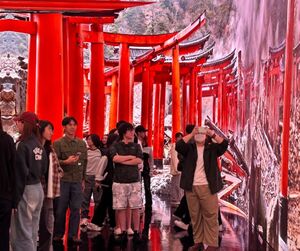 全創碩學生在虛擬攝影棚內與切換成日本鳥居背景的 LED 螢幕互動，彷彿置身真實場景，興奮地拍照留念，體驗科技的無限可能。（照片來源：全創碩）(另開新視窗/jpg檔)圖片